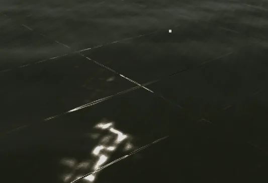 Broken bright streaks across an early reflective water shader